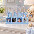 Baby-blue BABY photo magnet display with four photos on a nursery dresser beside a teddy bear and books.