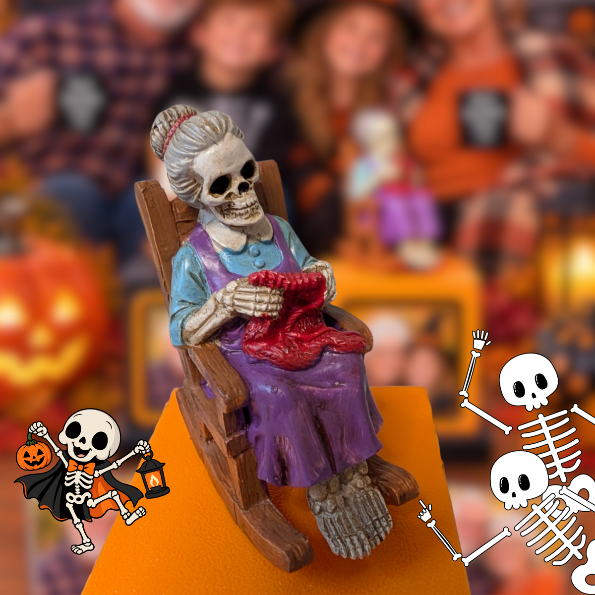 A Halloween memory cube with a skeleton woman sitting in a rocking chair and knitting a red sweater, displayed on an orange cube with a blurred festive background and cartoon skeleton graphics at the bottom corners.
