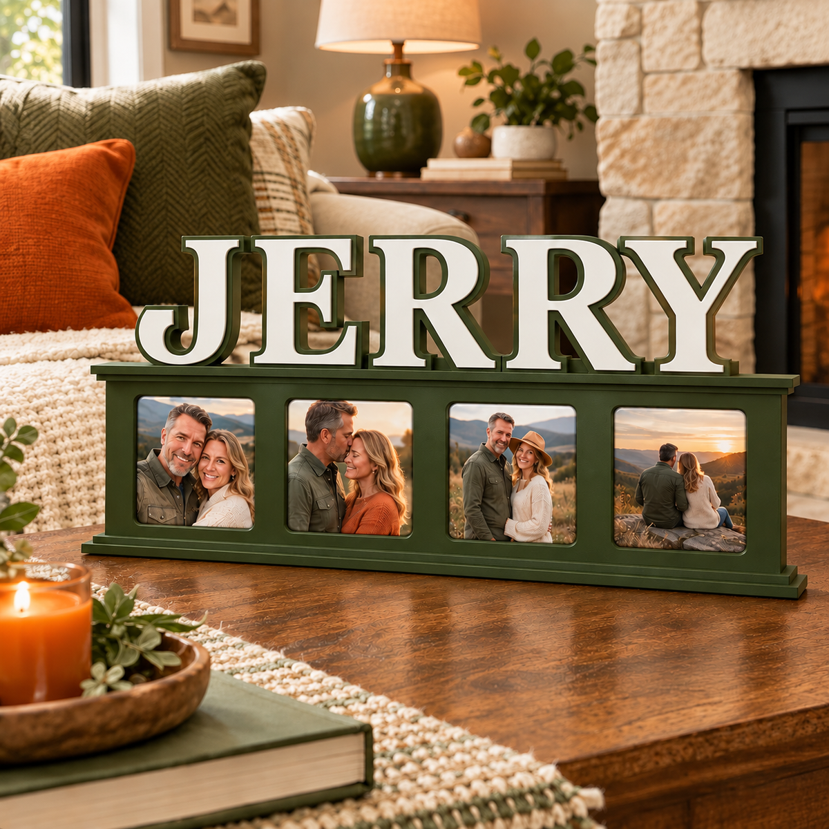 A personalized picture frame display spelling 'JERRY' in large white letters, mounted on a dark green frame with five photo slots. The sign is styled on a wooden table in a cozy living room setting with a fireplace, sofa, and candles.