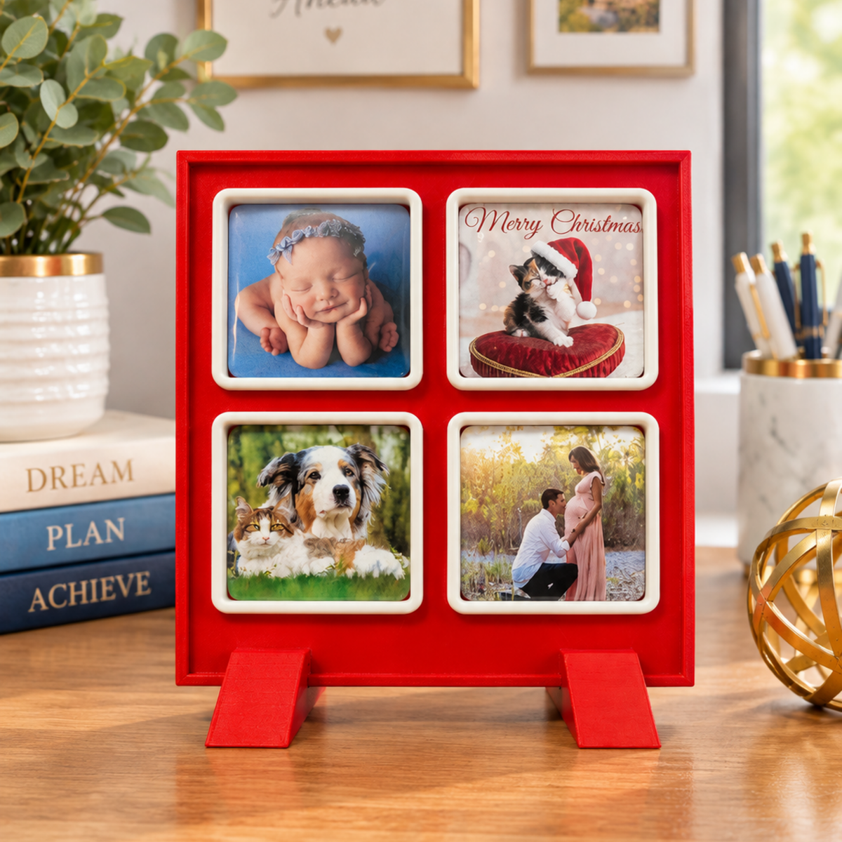 A red square photo frame stand with four photo magnets of the family, displayed on a wooden desk in a styled home office setting.
