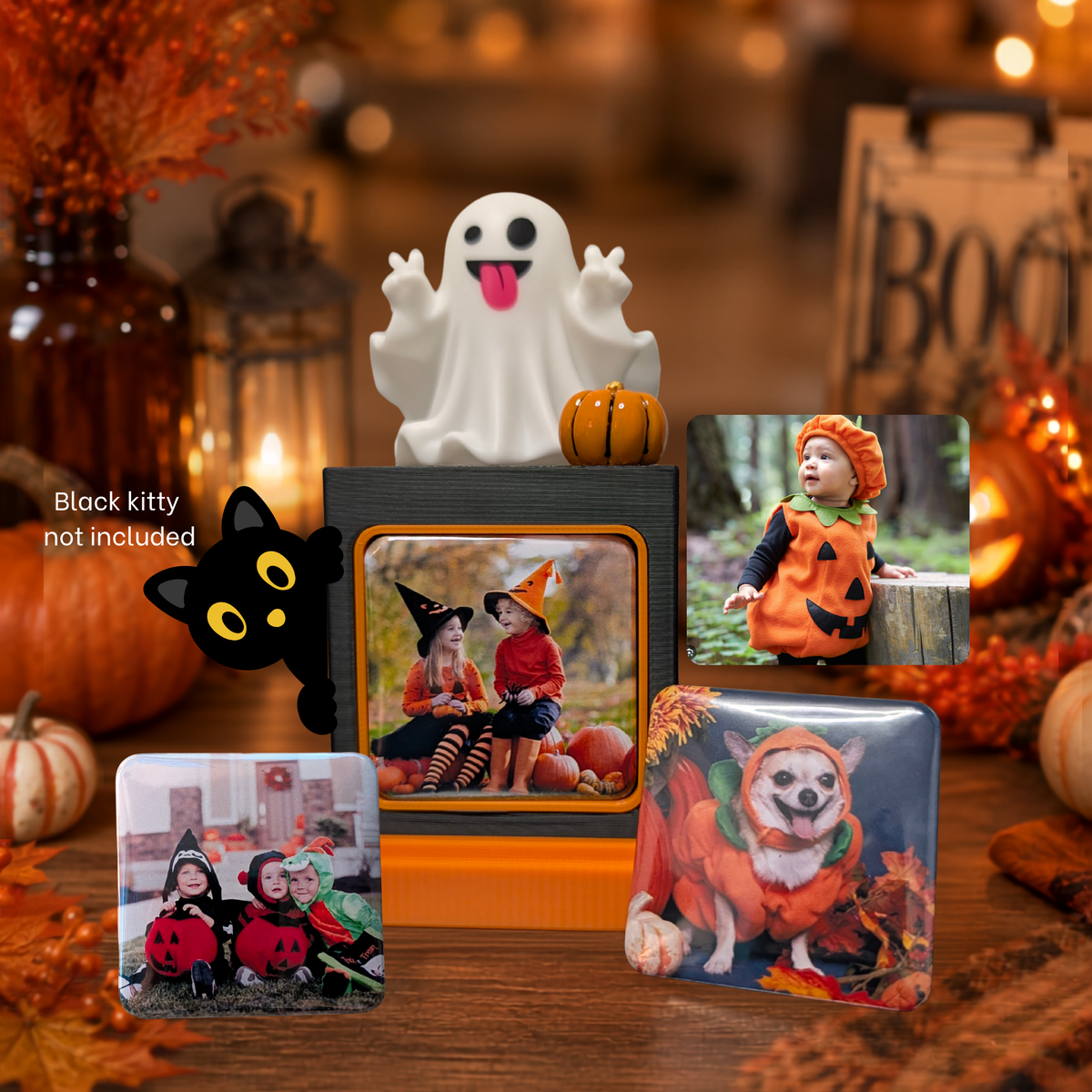 A Halloween-themed photo display with a white silly ghost,  an orange little pumpkin, three photo magnets arranged on a wooden table. A black cat element print not included.
