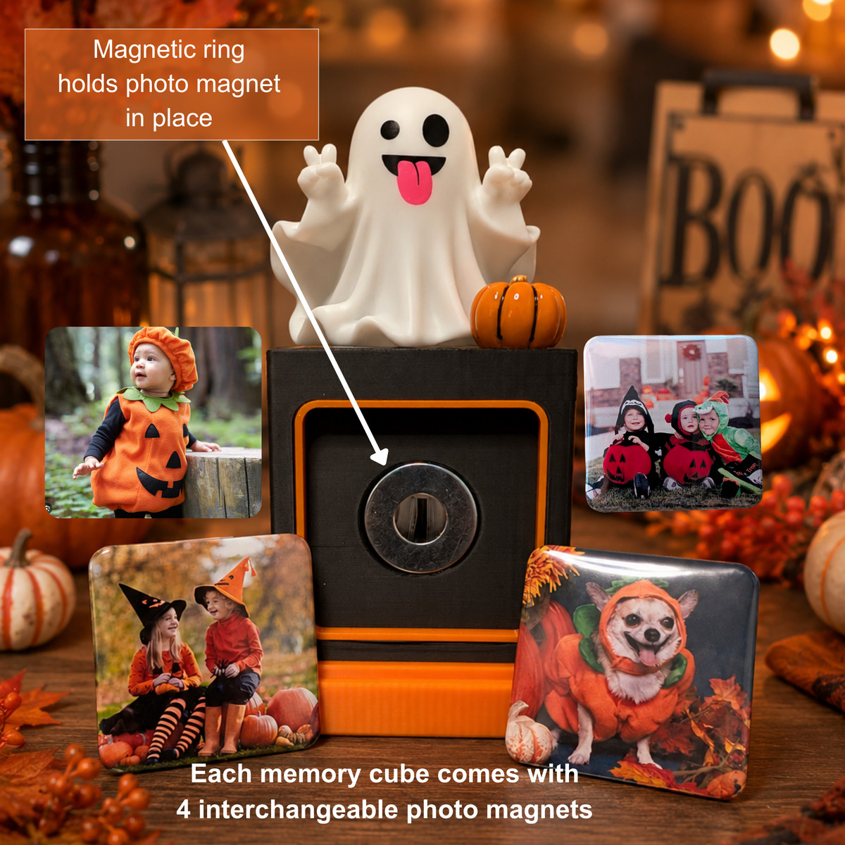 A Halloween-themed photo magnet display set on a wooden table, featuring a white ghost figurine with a magnetic ring, a small orange pumpkin, and several square photo magnets showing children in costumes and a dog in a pumpkin outfit. Text overlays explain the magnetic ring and the interchangeable photo magnets.